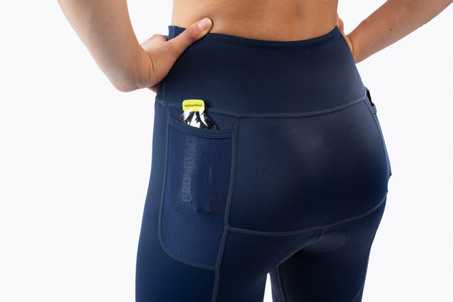 Navy blue athletic triathlon shorts worn by a person on a white background