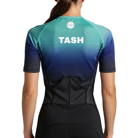 Person wearing a gradient trisuit with 'TASH' personalised name print on a light gray background