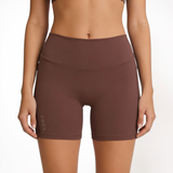 Brown athletic shorts worn by a person on a white background