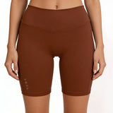 Brown athletic shorts worn by a person on a white background