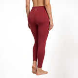 Maroon red athletic gym yoga leggings worn by a person on a white background