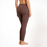 Brown athletic gym yoga leggings worn by a person on a white background