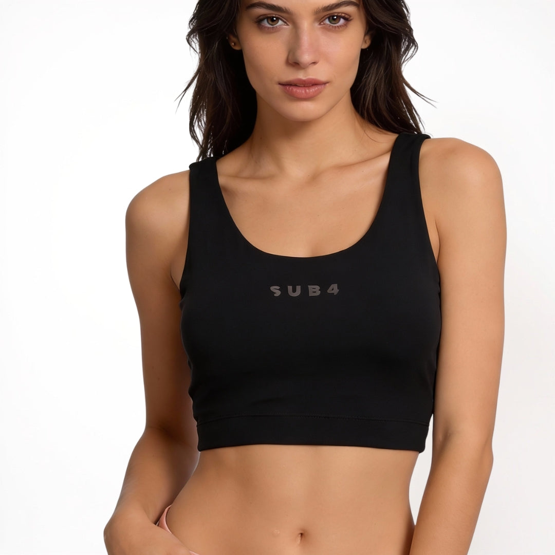 Woman wearing a black sports bra with 'SUB4' branding on a white background