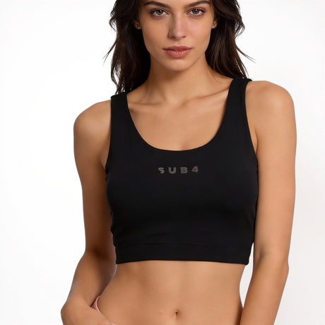 Woman wearing a black sports bra with 'SUB4' branding on a white background