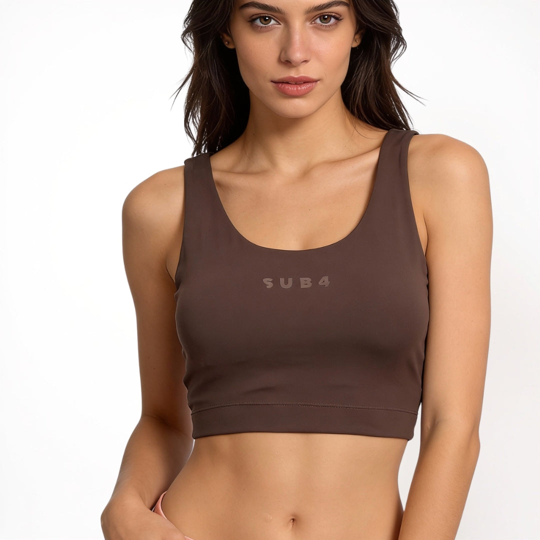 Woman wearing a brown sports bra with 'SUB4' branding on a white background